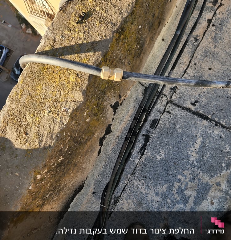 צינור עם מחבר מתכת על גג בטון